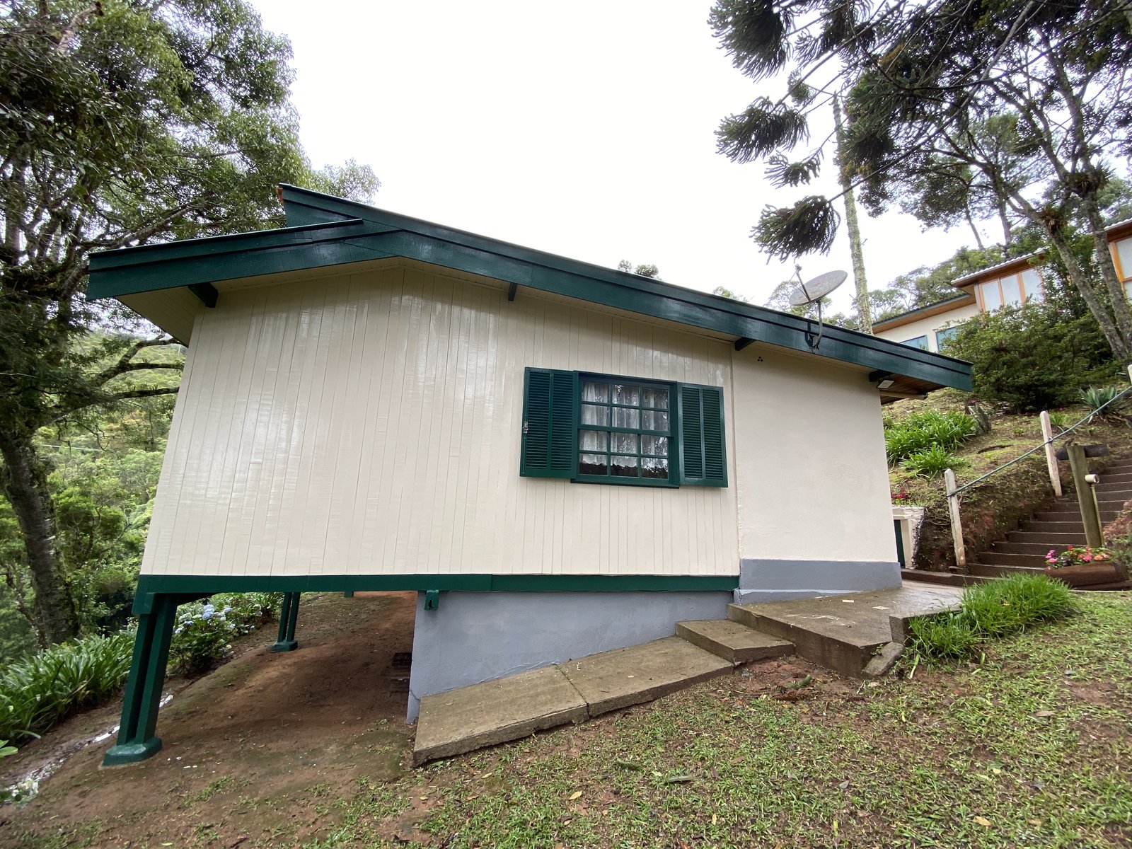 Fachada do chalé com estrutura suspensa em madeira